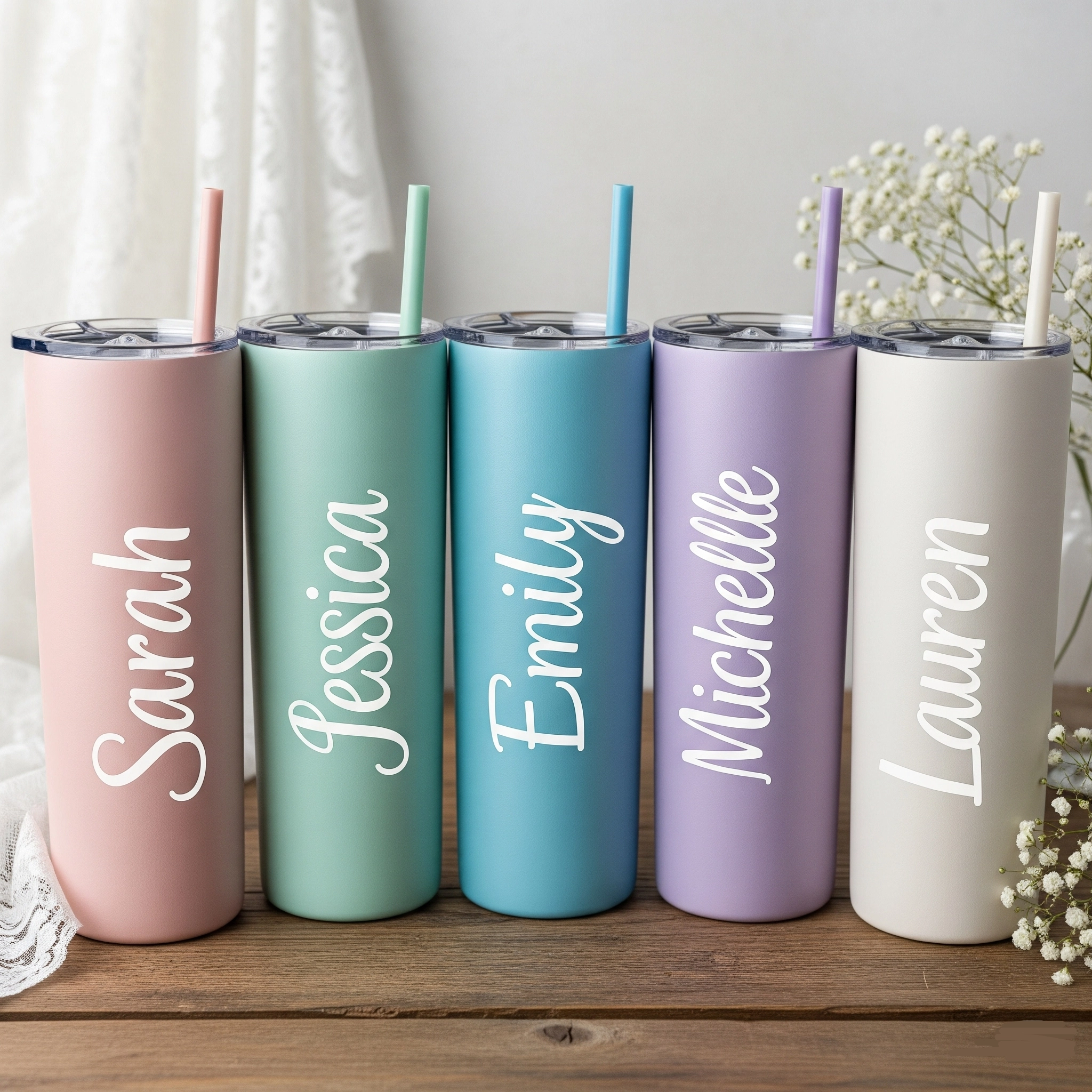 Row of five custom skinny tumblers with different names for bridesmaid gifts.